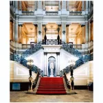 Fotografia de Candida Höfer intitulada Biblioteca Nacional do Rio de Janeiro V (2005), retratando uma escadaria monumental com carpete vermelho e arquitetura neoclássica.